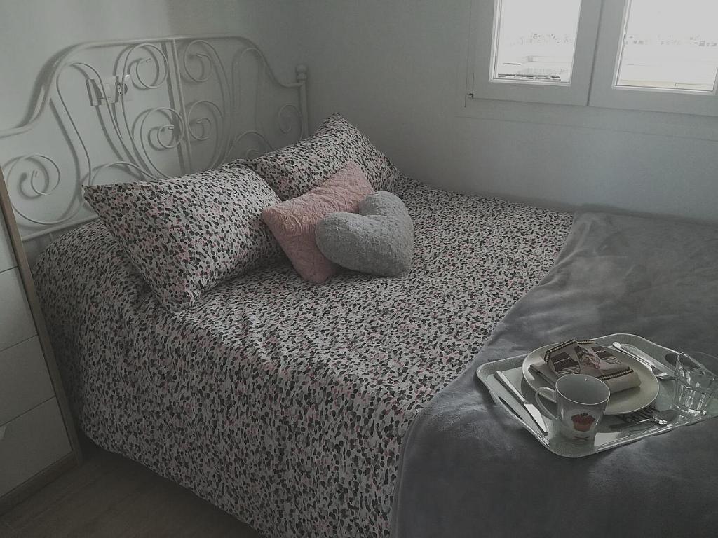 ein Teddybär auf einem Bett mit einem Tablett mit Essen in der Unterkunft Bay Home in Cádiz