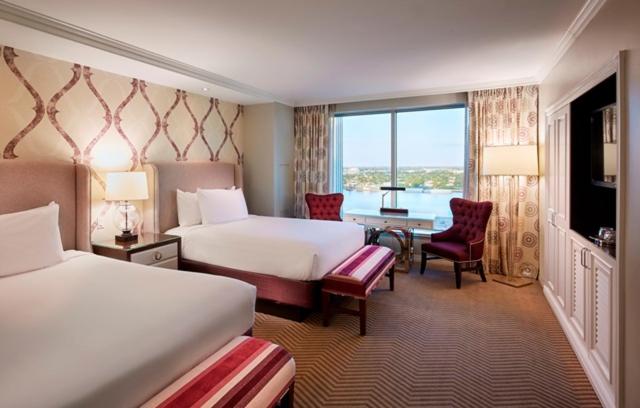 a hotel room with two beds and a table and chairs at Harrah's New Orleans Hotel & Casino in New Orleans
