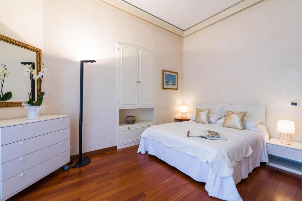 ボルディゲーラにあるVilla Eugenia - Luxury Flat with Parking Spaceのベッドルーム(白いベッド、ドレッサー、鏡付)