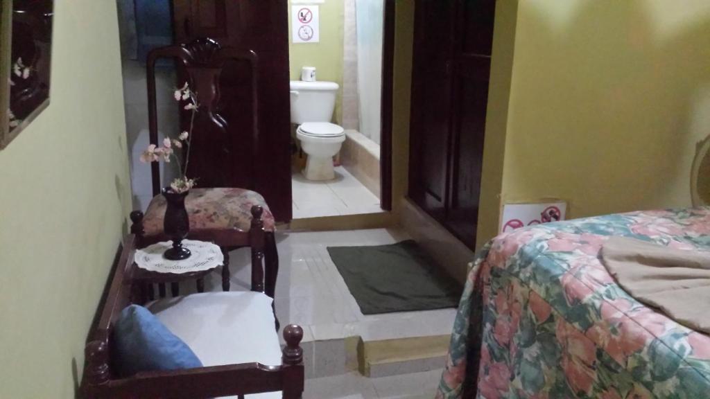 a room with a bedroom with a bed and a toilet at B&B KeisyAlba Punta Rucia in Punta Rucia