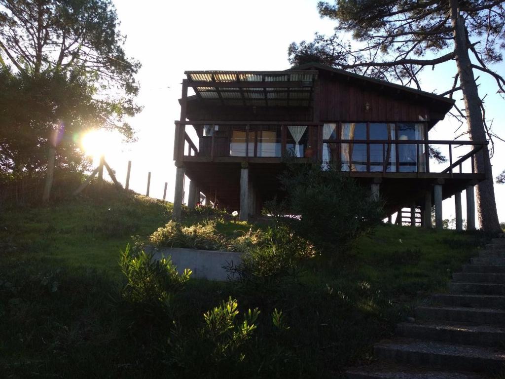 una casa sentada en la cima de una colina con escaleras en Cabaña en la playa. ventanales y terraza al mar, en Salinas