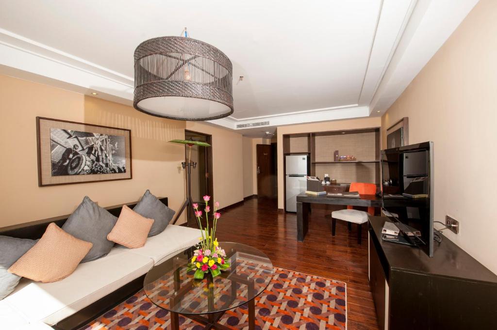 a living room with a couch and a table at Rose Garden Hotel in Yangon