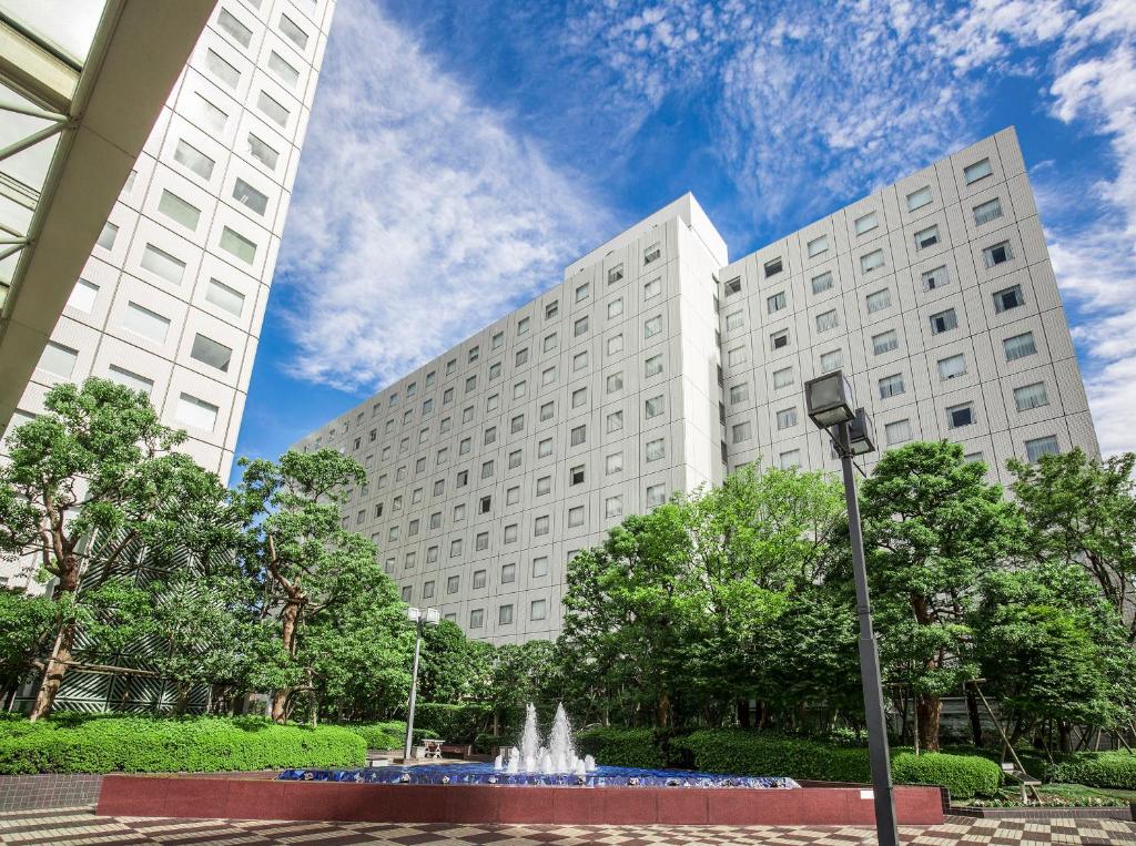 東京的住宿－東京新大谷旅館，两座大型白色建筑,前面有一个喷泉