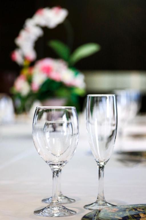 two empty wine glasses sitting on a table with flowers at New Otani Inn Tokyo in Tokyo