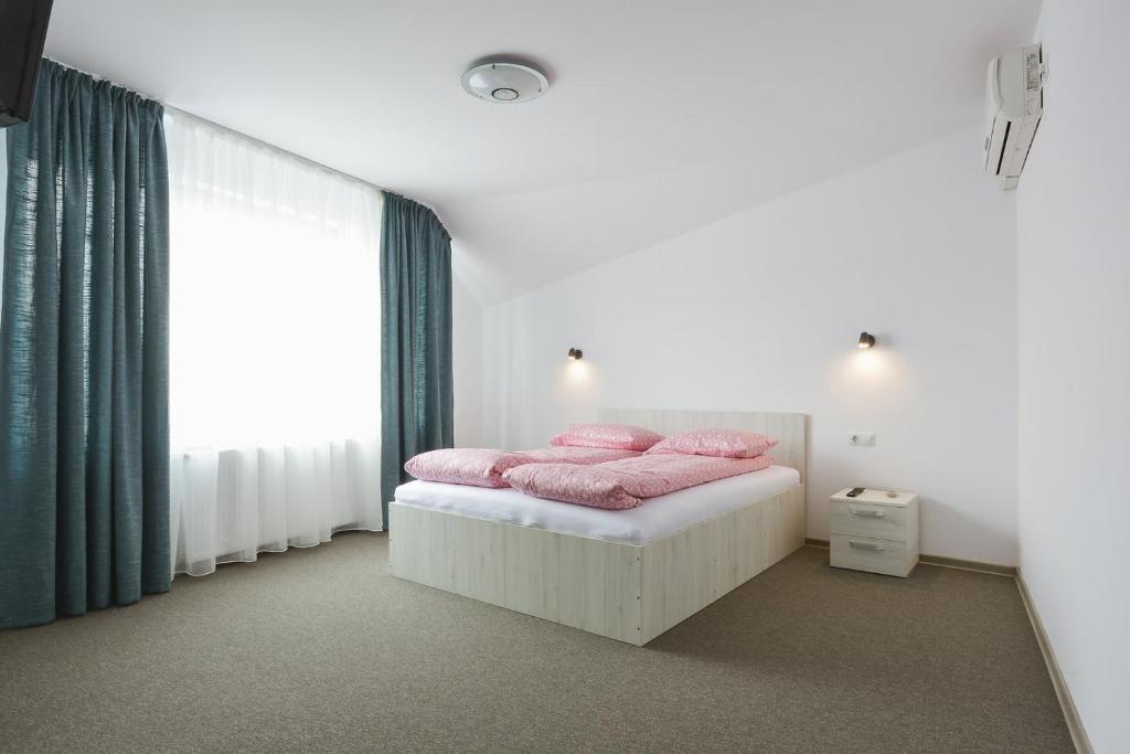クルジュ・ナポカにあるCasa Verona Centruのベッドルーム1室(ピンクの枕が付いたベッド1台付)