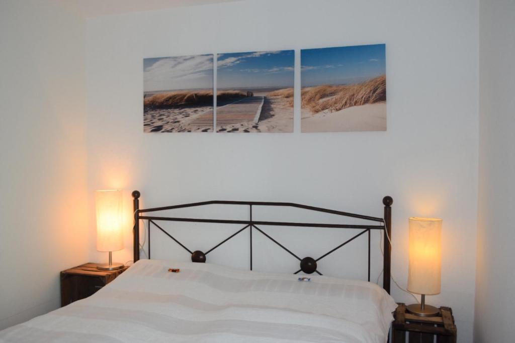 1 dormitorio con 1 cama con 3 cuadros en la pared en Tango Ferienwohnung Winnenden, en Winnenden
