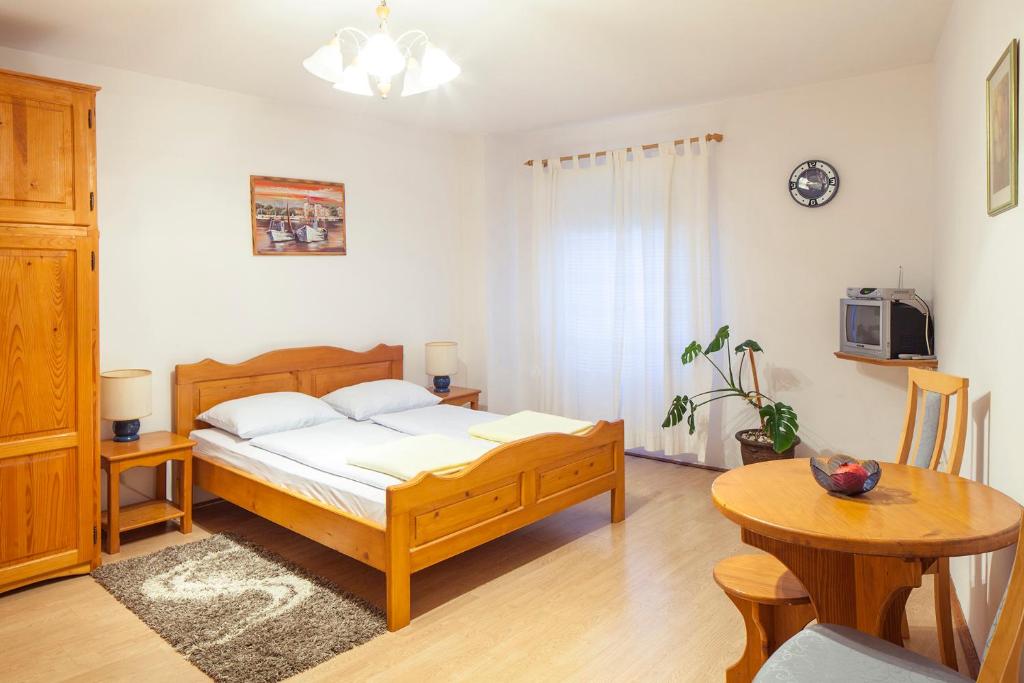 a bedroom with a large bed and a table at Mon Perin Castrum - Studio Apartment Castel in Bale