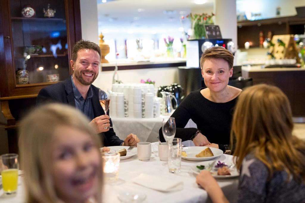 Eine Gruppe von Menschen, die an einem Tisch sitzen und Essen essen. in der Unterkunft Montra Hotel Sabro Kro in Sabro