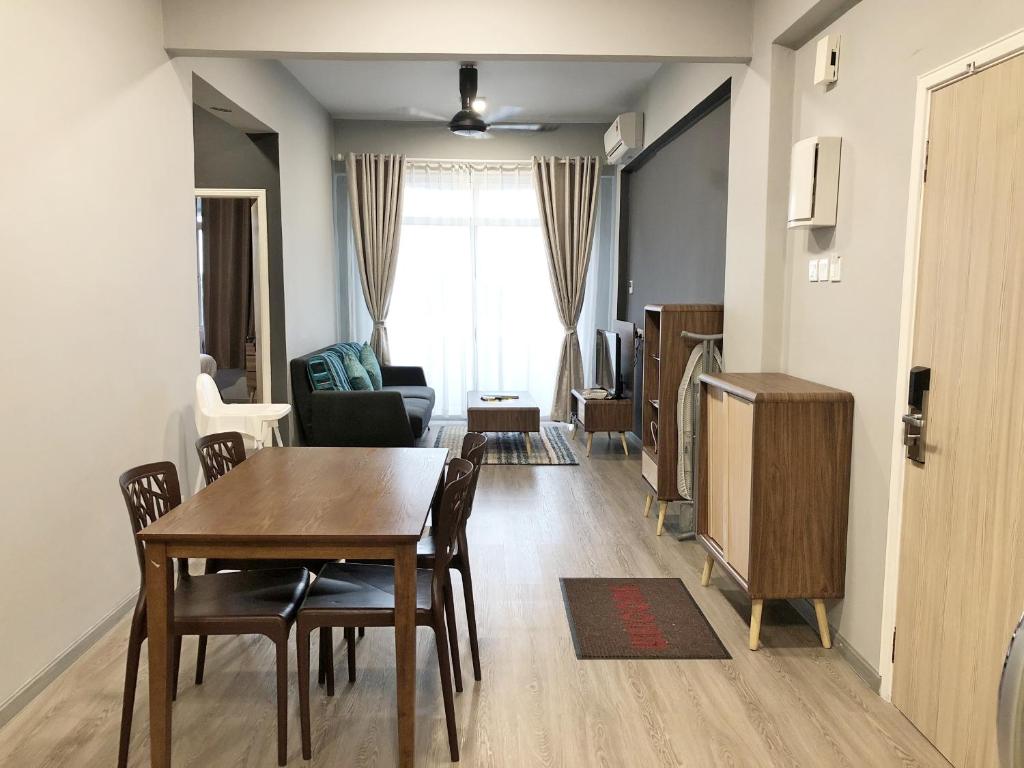 a living room with a dining room table and a television at Seaview Apartment in Kuah