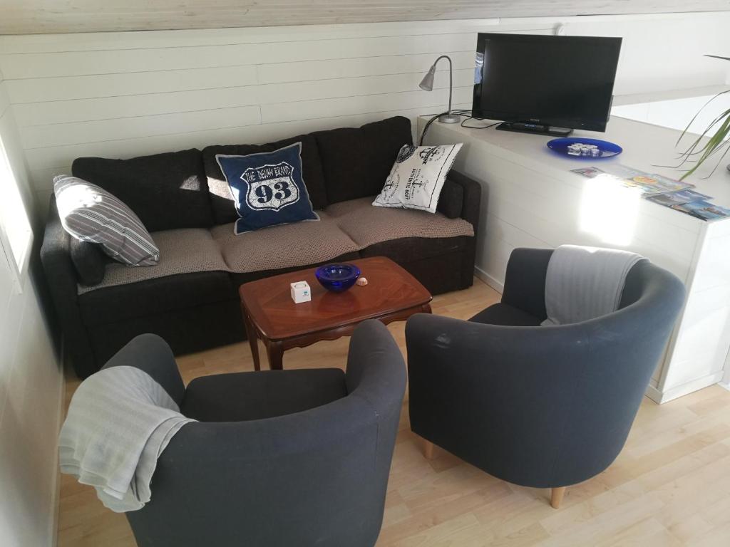 een woonkamer met een bank en 2 stoelen bij Åsarna Hills Holiday Home Stillingsön in Stillingsön
