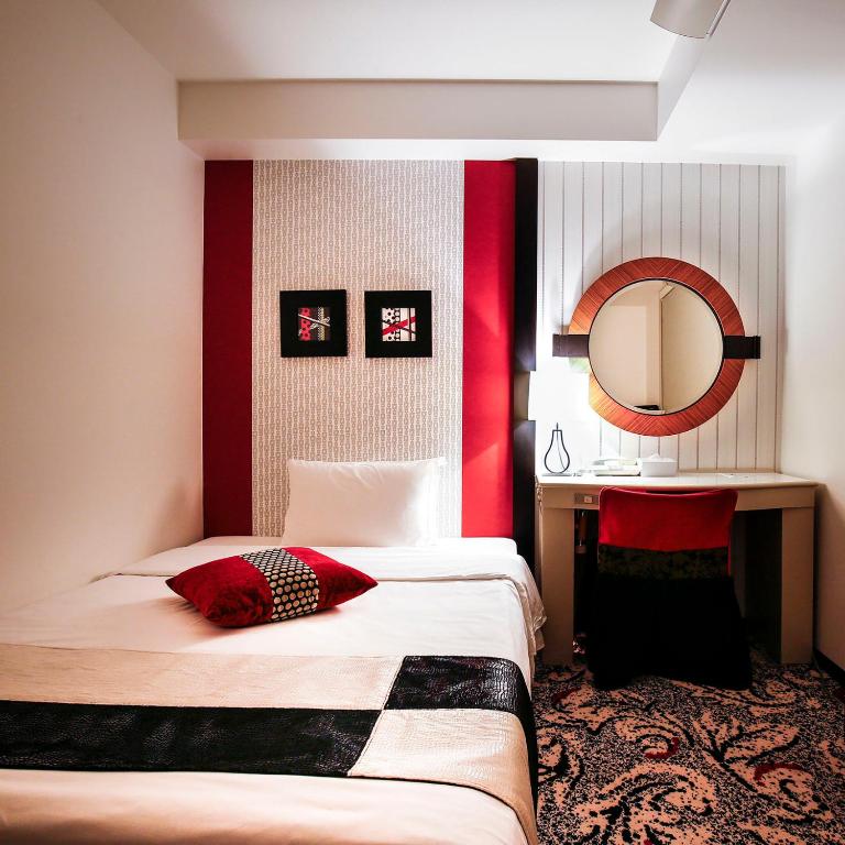 a hotel room with a bed and a mirror at New Otani Inn Tokyo in Tokyo