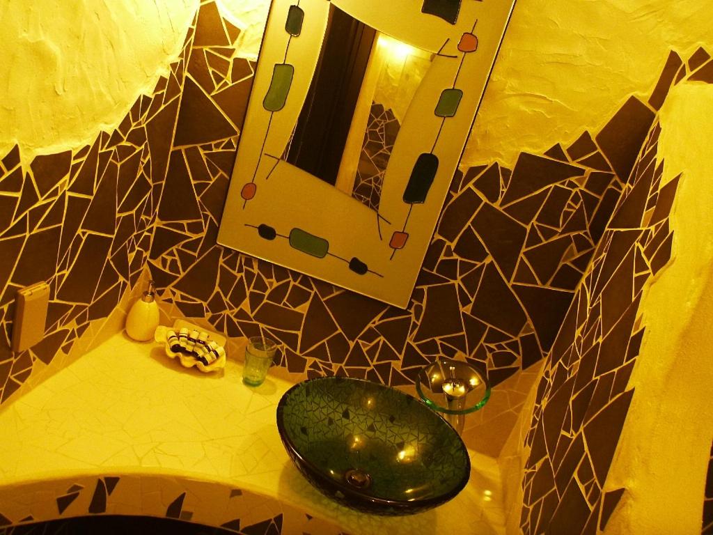 a bathroom counter with a mirror and a green sink at Taketomijima Akaneya in Taketomi