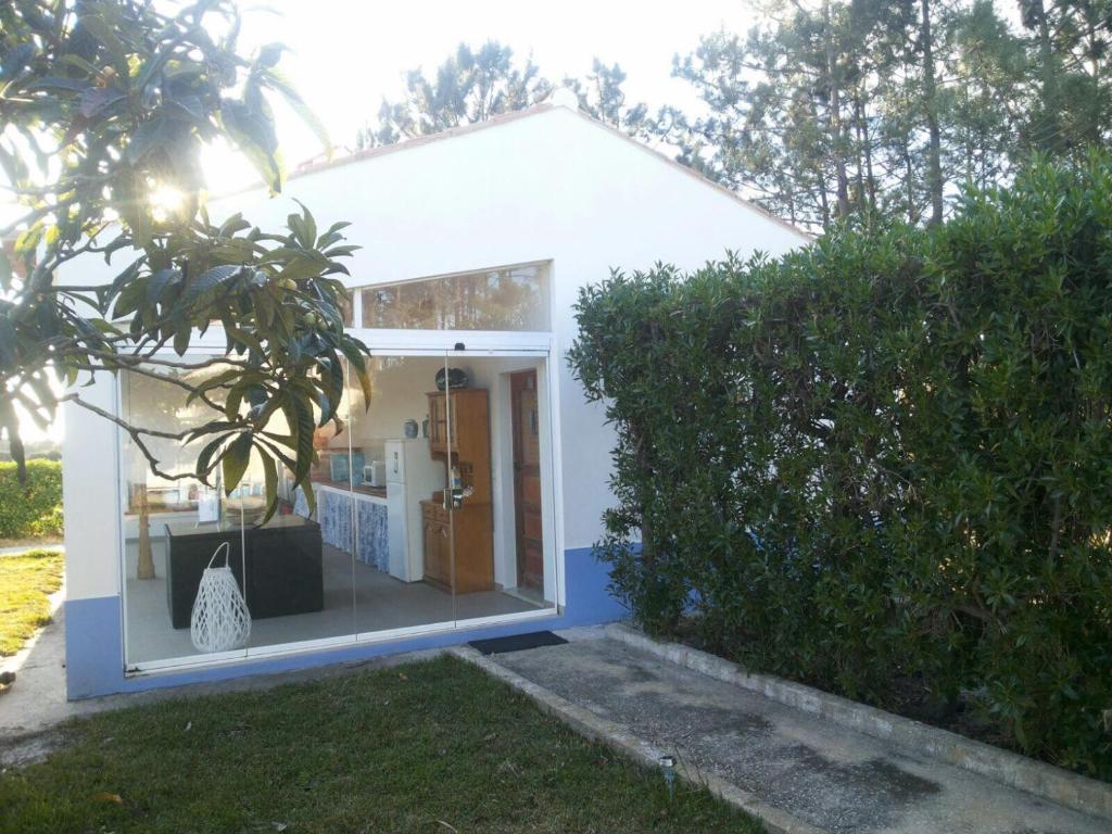 mały biały dom z dużym oknem w obiekcie Casa da Samouqueira w mieście Rogil