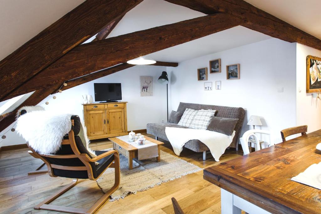 a living room with a couch and a chair at Hissla Riquewihr Apartments in Riquewihr