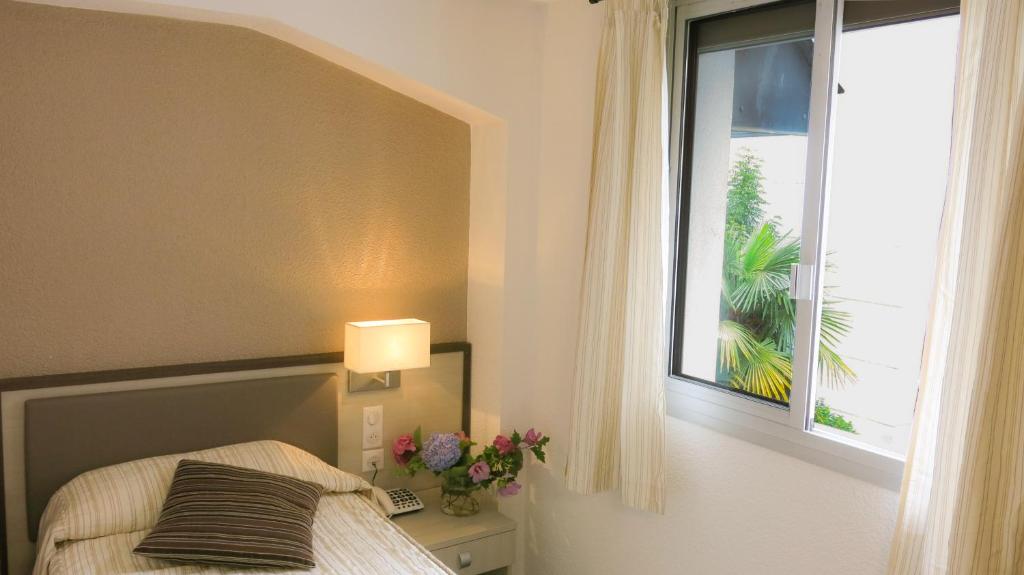 Una cama o camas en una habitación de Hôtel La Source