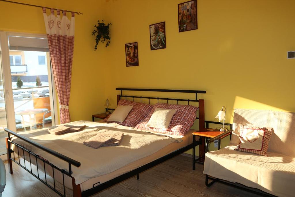 1 dormitorio con cama, mesa y ventana en Apartmán Beta Podhájska, en Podhájska