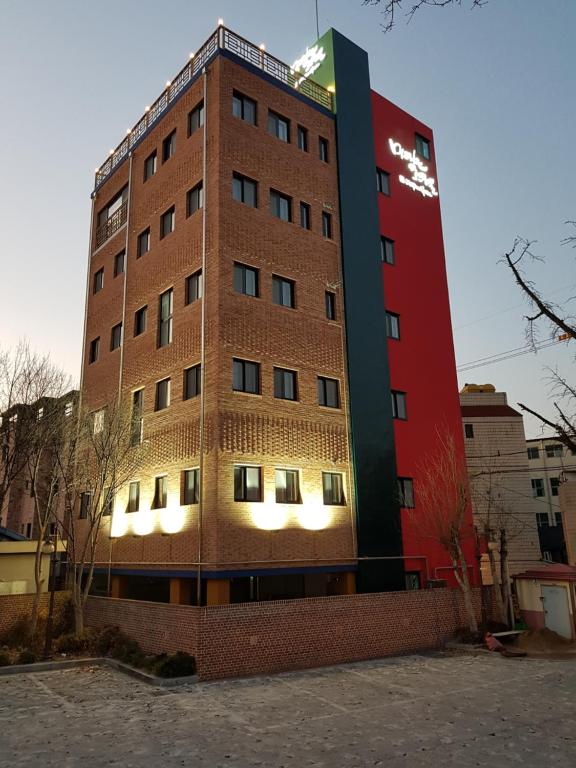 um edifício de tijolos alto com um vermelho e verde em Daegu Midtown Hostel em Daegu