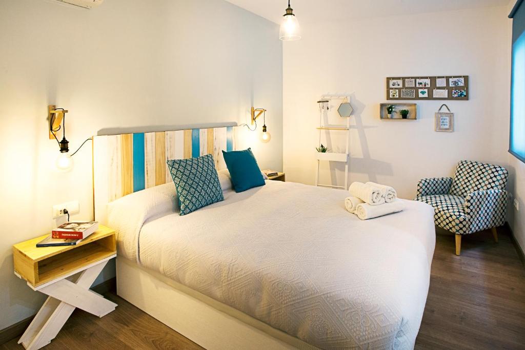 una piccola camera con letto e sedia di HI Suite Málaga Centro a Málaga