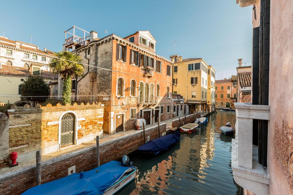 eine Gruppe von Booten in einem Kanal mit Gebäuden in der Unterkunft Sartor Apartment with Canal View and Private Court in Venedig