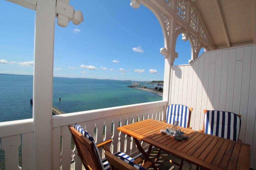 a porch with a table and chairs and the ocean at Fuerstenhof Appartement 401 in Sassnitz