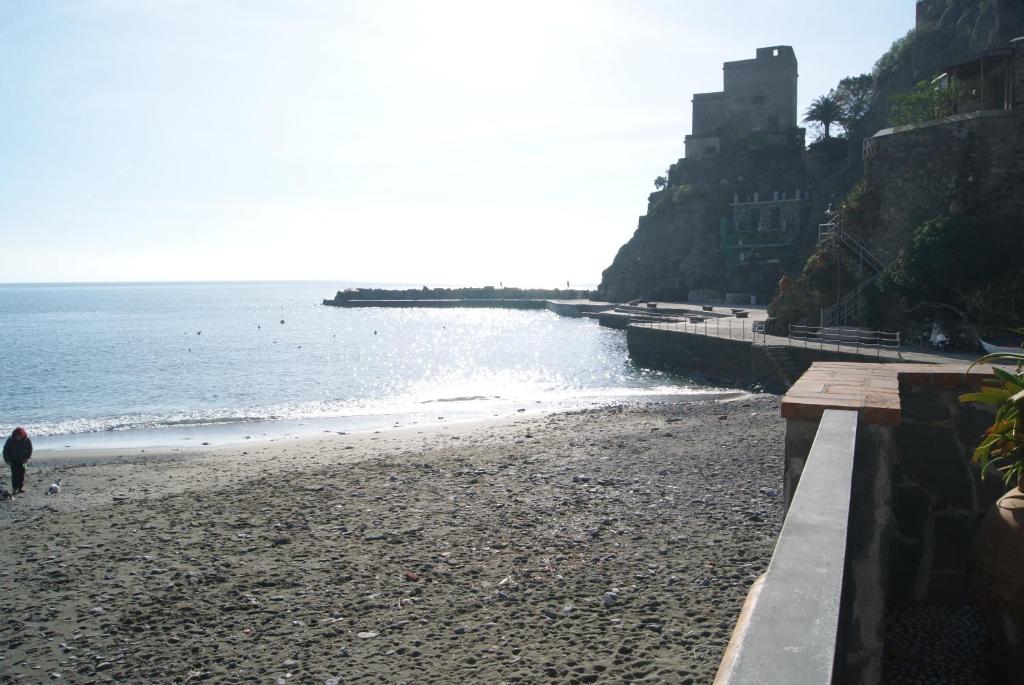 a person walking on a beach next to the ocean at Chez Tamara with private parking and air conditioned in Monterosso al Mare