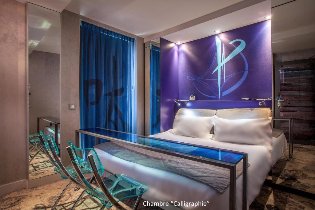 ein Schlafzimmer mit einem Bett mit einer lila Wand in der Unterkunft Apostrophe Hôtel in Paris