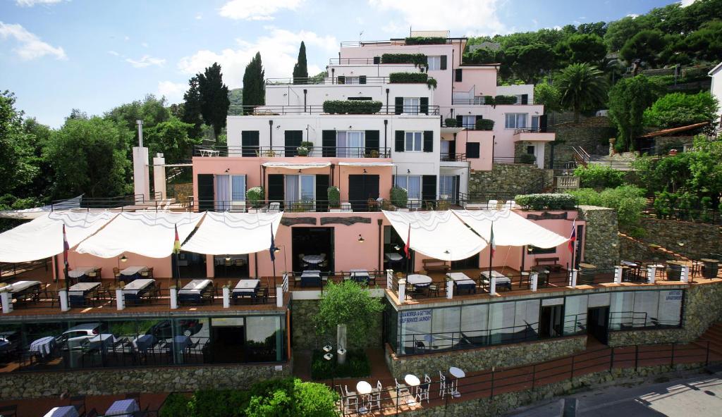 un gran edificio con mesas y sillas delante de él en Residence Borgo San Sebastiano, en Bergeggi