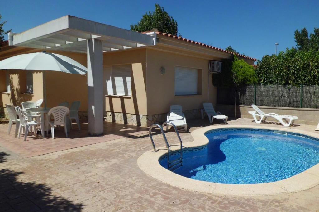 una piscina con patio y una casa en Casa Marga, en Riumar