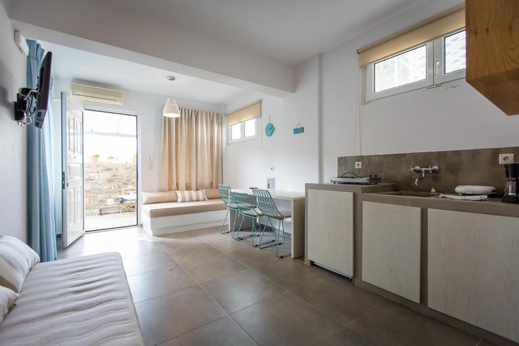 a kitchen and a living room with a table and chairs at Irene Studios in Agios Petros