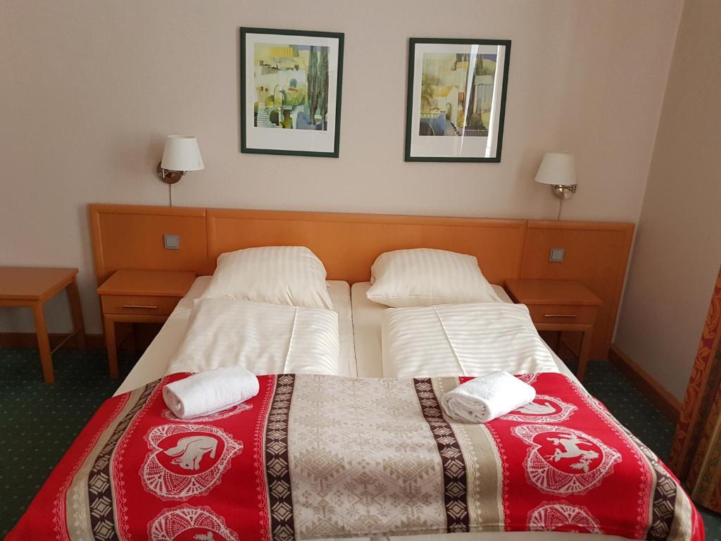 um quarto de hotel com duas camas e duas fotografias na parede em Mediterran em Hamburgo