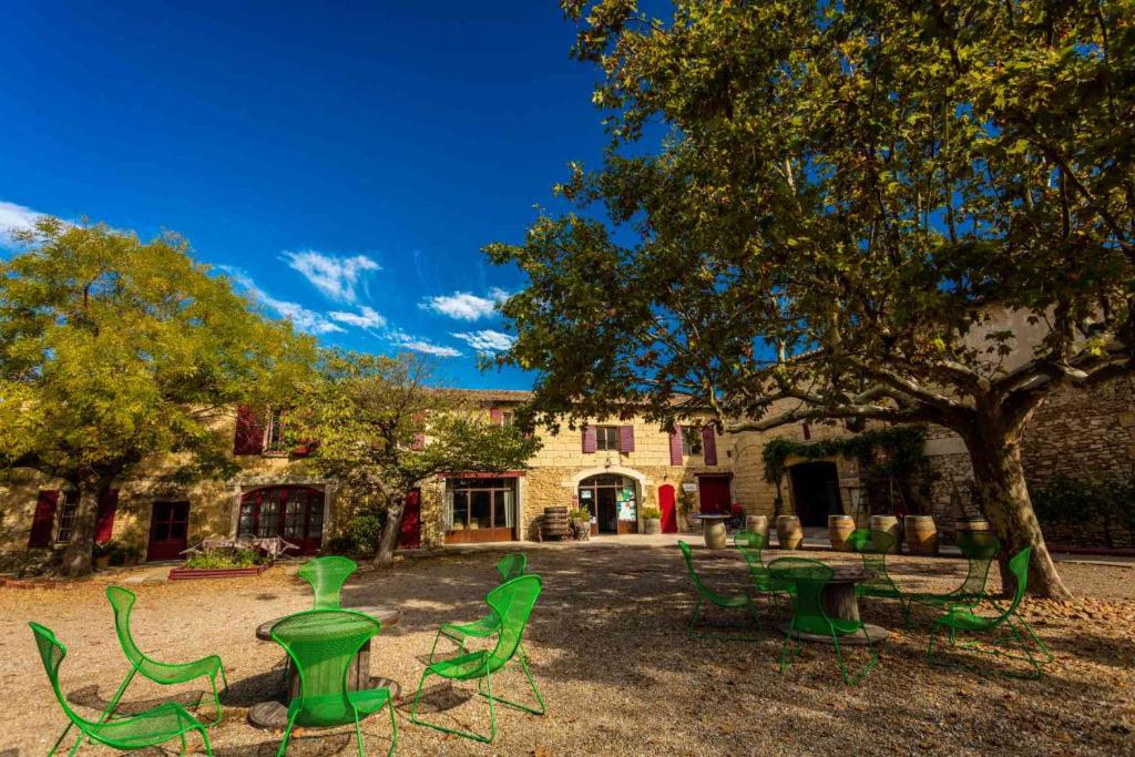 a group of green chairs in front of a building at Mas du Notaire in Gallician