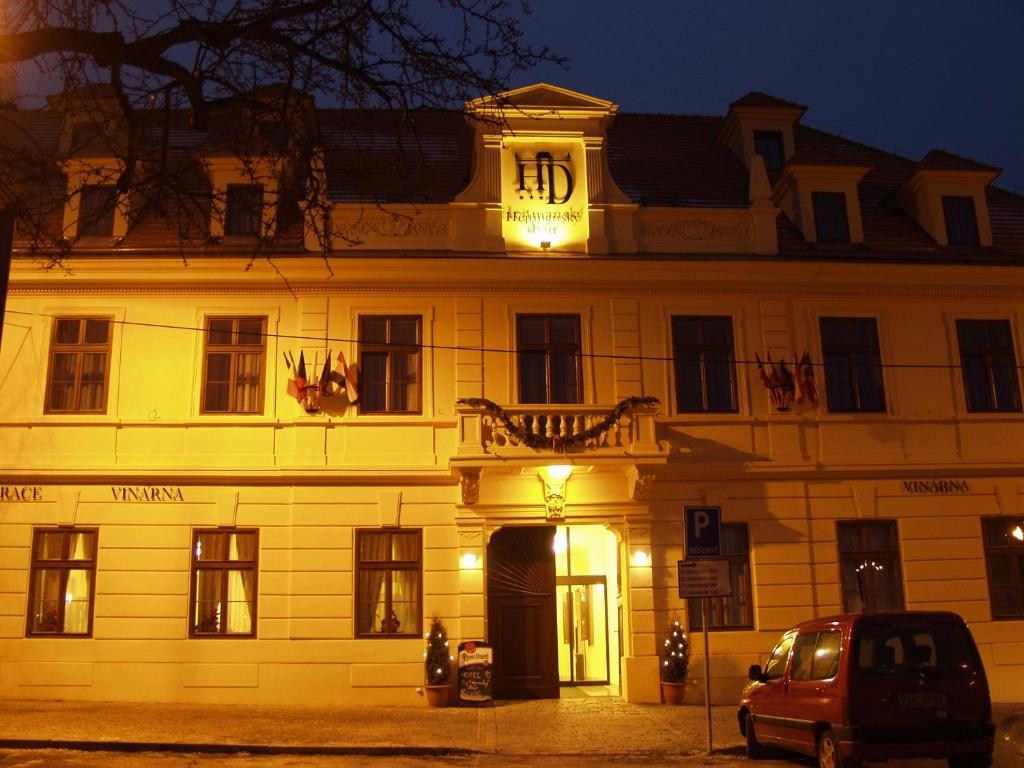 un edificio con un reloj encima por la noche en Hejtmanský dvůr, en Slaný
