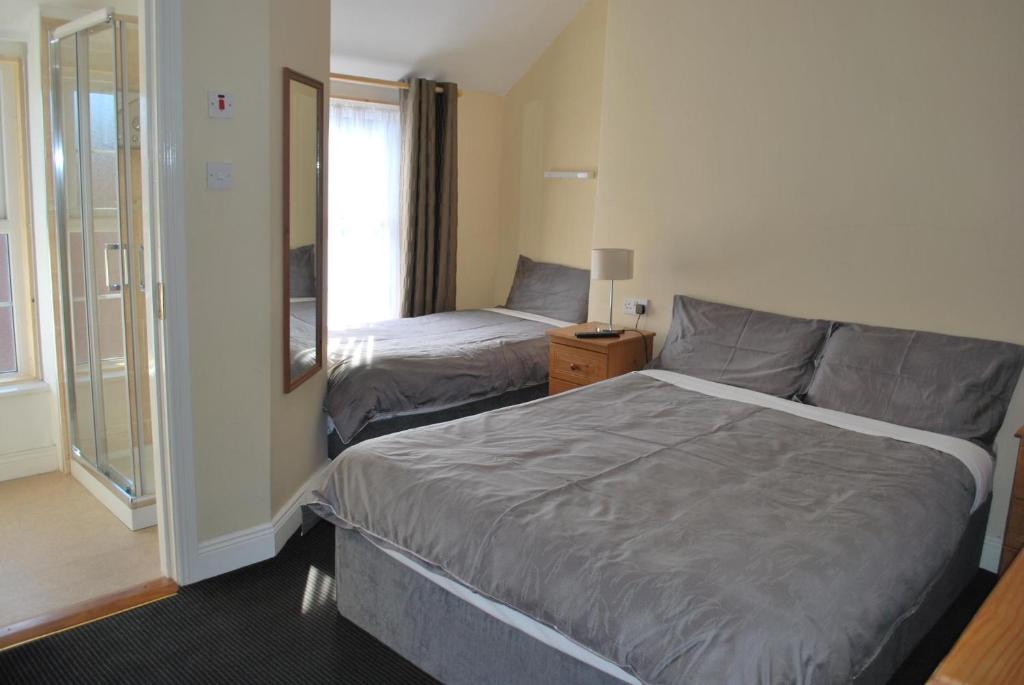 um quarto de hotel com uma cama e uma janela em Parkway Guesthouse em Dublin