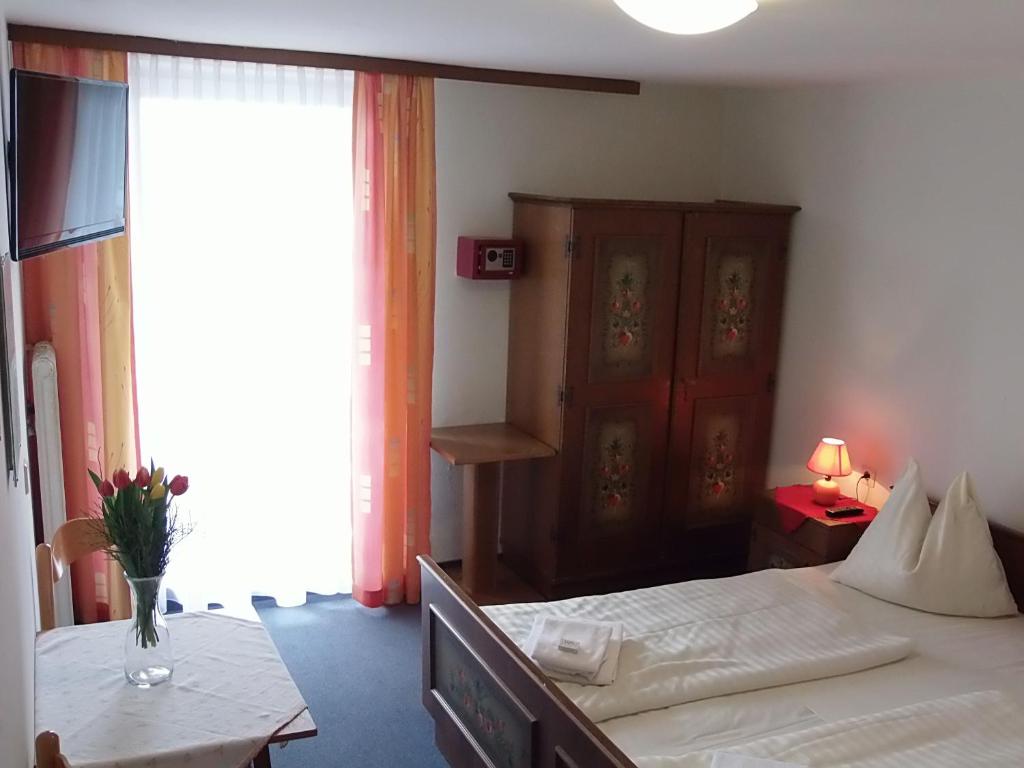 a bedroom with a bed and a table and a window at Götschlhof in Schladming