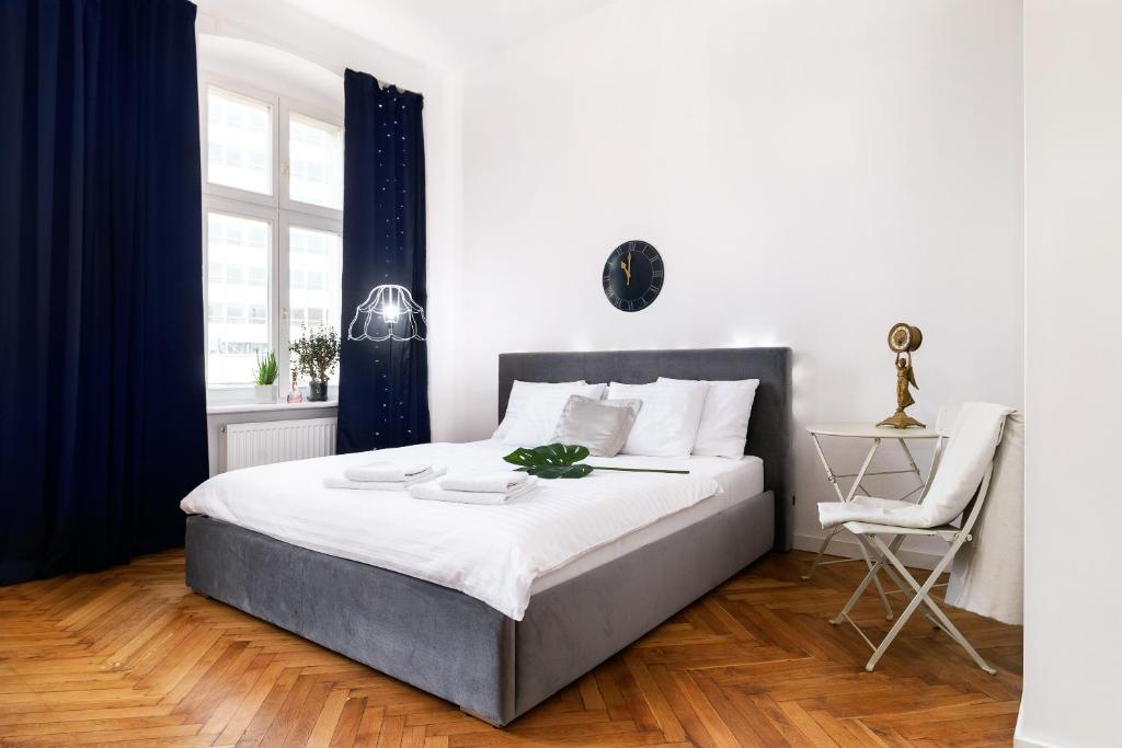 ポズナンにあるOZONOWANE Apartamenty St Martin Poznan Centrumのベッドルーム(大型ベッド1台、椅子付)