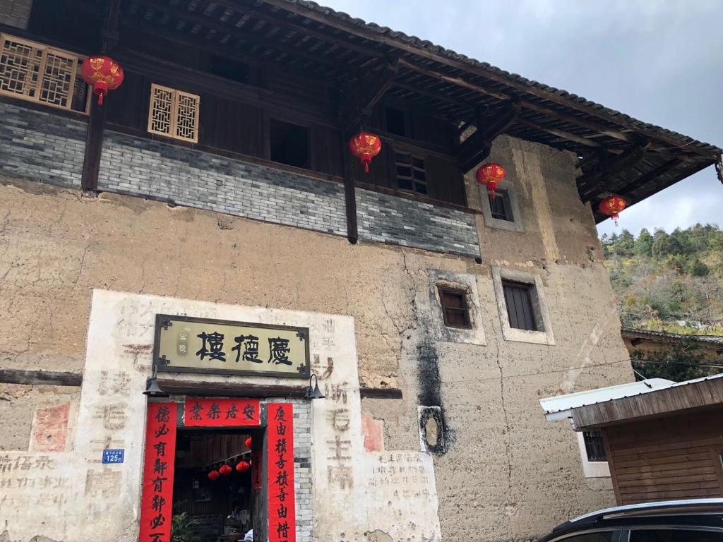 un bâtiment avec une porte rouge devant lui dans l'établissement Nanjing Tulou Qingdelou Inn, à Nanjing