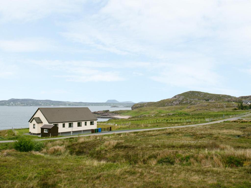 a house on a hill next to the water at 1 Bayview Bungalow in Poolewe