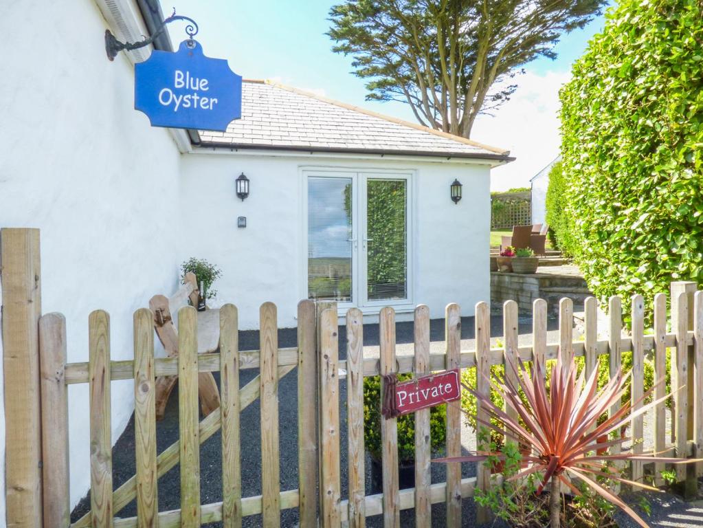 a wooden fence in front of a white house at Blue Oyster in Mullion