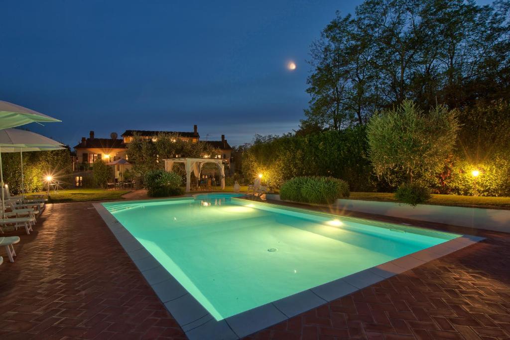 una piscina in un cortile posteriore di notte di Appartamento in Casale toscano a Orentano