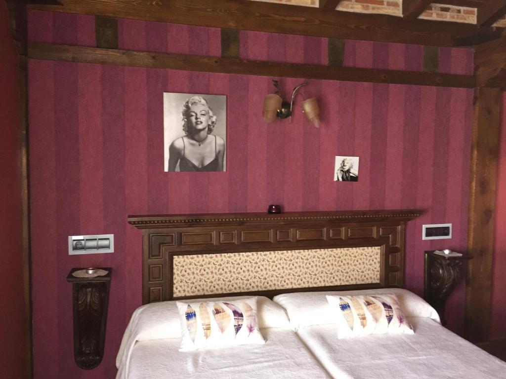 un dormitorio con una cama y una foto de un hombre en El Lagar, en Canalejas de Peñafiel
