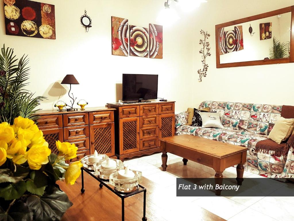 a living room with a couch and a table at Pretty Bay Apartments in Birżebbuġa