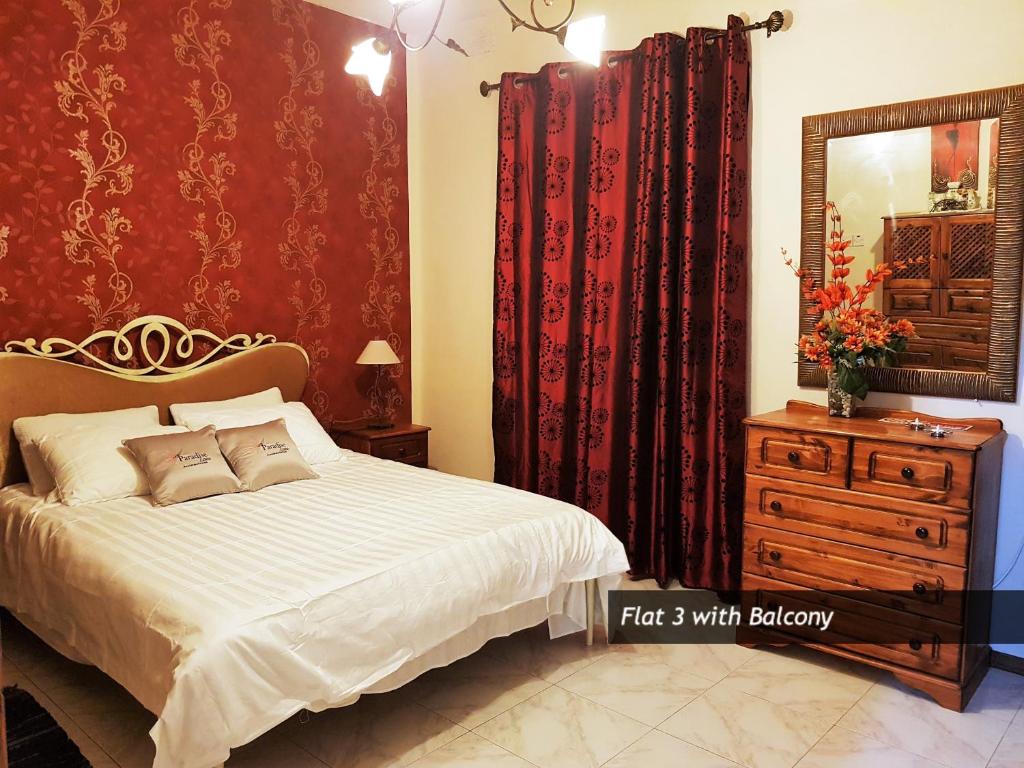 a bedroom with a bed and a mirror and a dresser at Pretty Bay Apartments in Birżebbuġa
