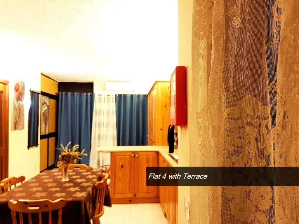 a dining room with a table and blue curtains at Pretty Bay Apartments in Birżebbuġa