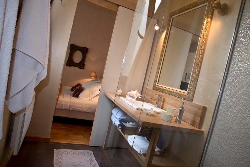 a bathroom with a sink and a mirror and a bed at Les Chambres de l'Abbaye in Marseille