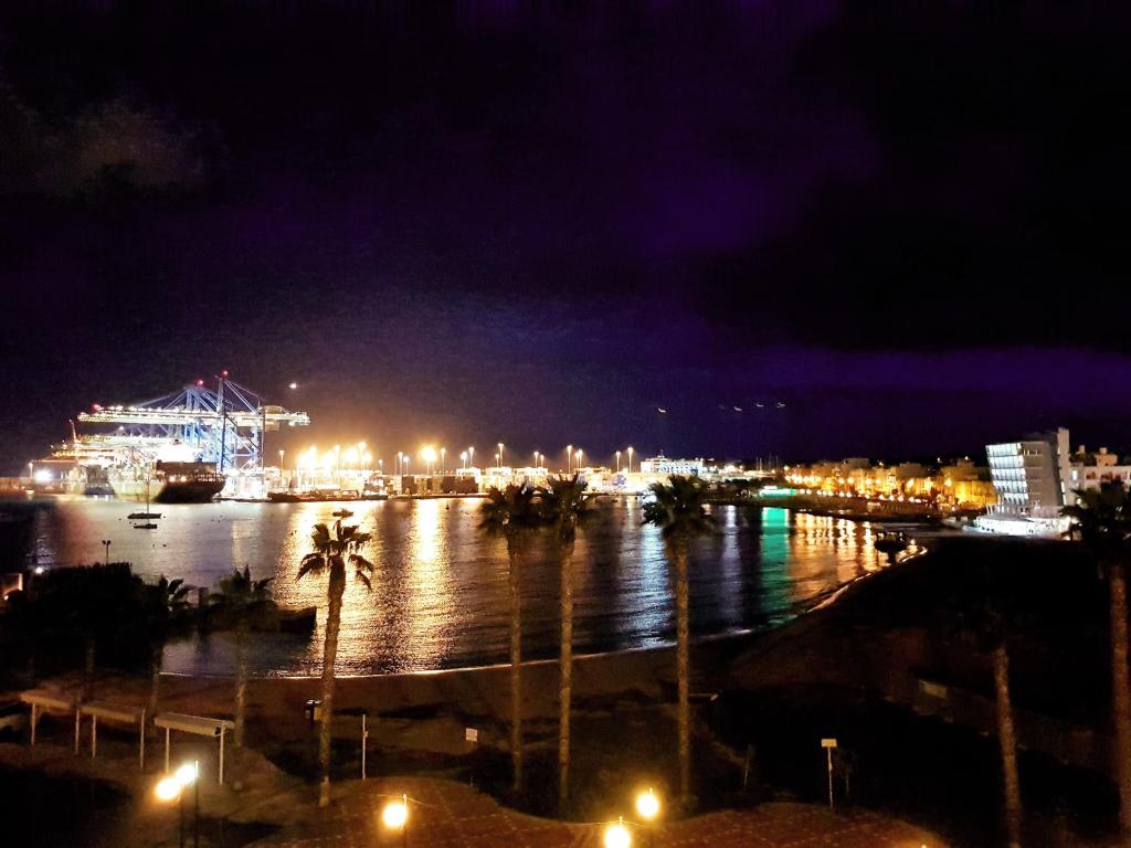 a view of a harbor at night with a cruise ship at Pretty Bay Apartments in Birżebbuġa