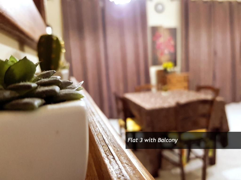 a view of a living room with a table and a plant at Pretty Bay Apartments in Birżebbuġa
