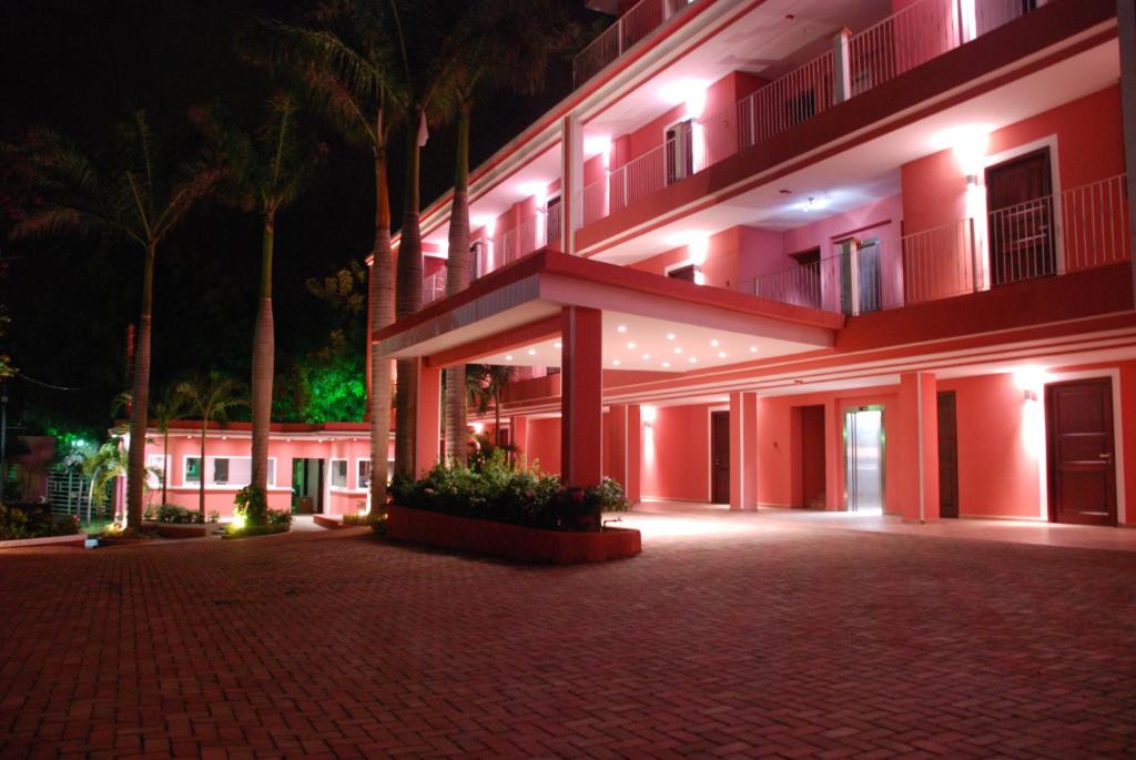 a large building with red lights in the night at Hotel RDG in Managua