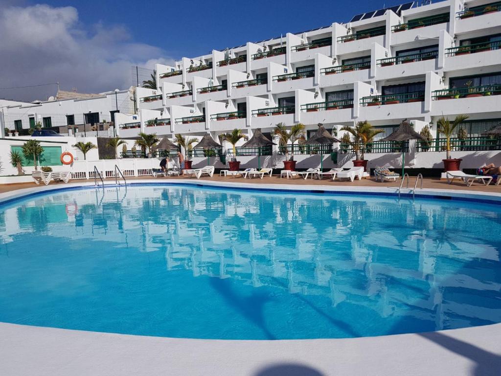 a large swimming pool in front of a large building at Apartamentos La Florida in Puerto del Carmen