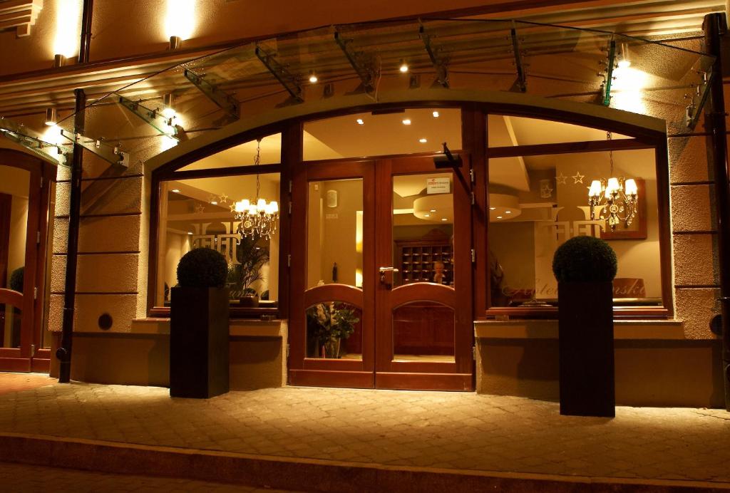 Hotel Tumski في بلوك: واجهة متجر مع باب زجاجي كبير في الليل