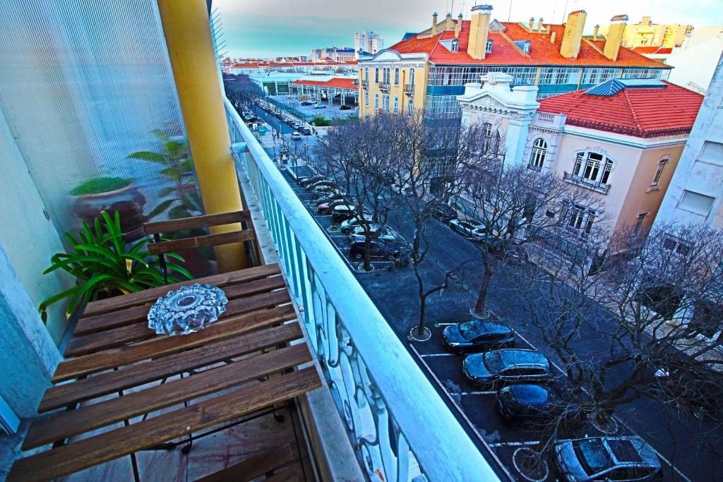 a balcony with a wooden bench and a view of a city at Residencial Duque de Saldanha in Lisbon